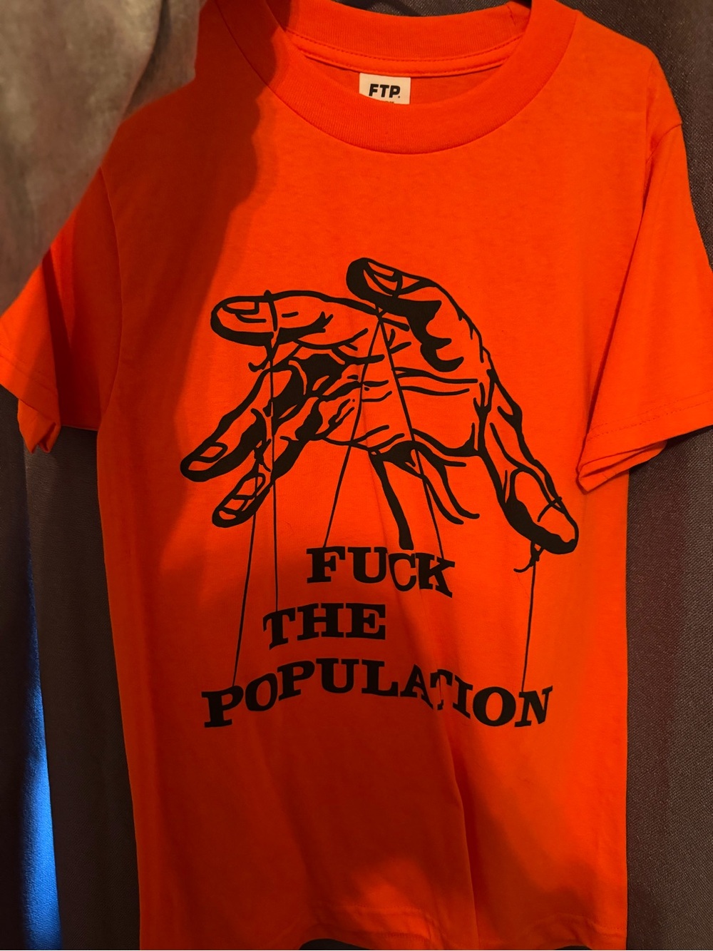 FTP Bright Orange Tee with Black Puppet Hand Graphic